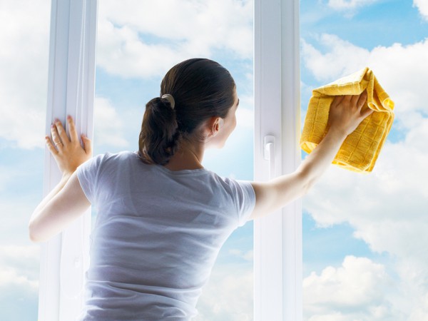 Young woman washing windows